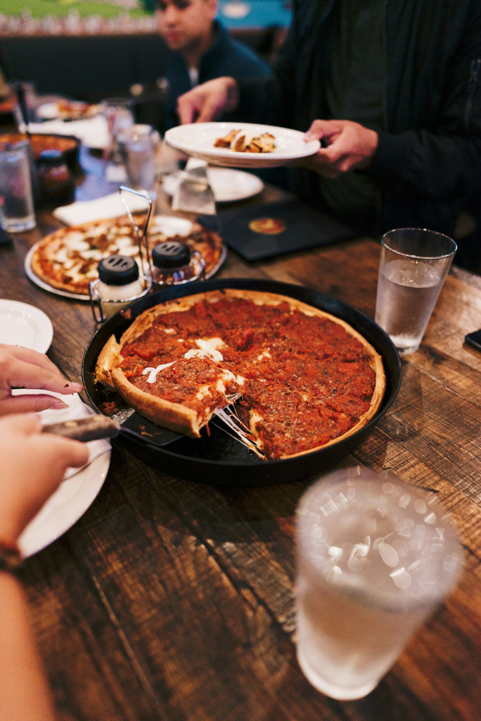 Pizza being shared around a restaurant table